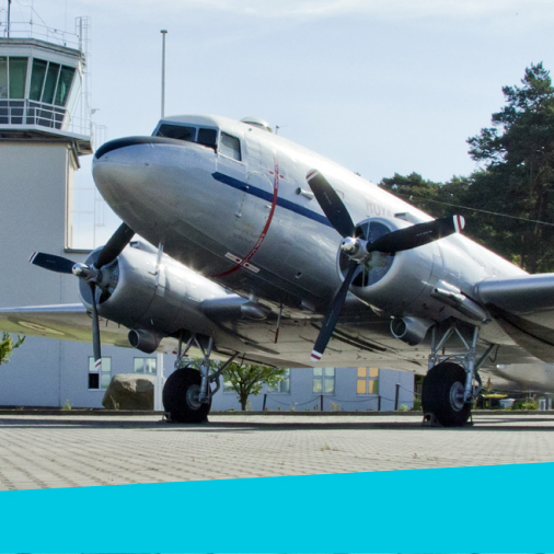Auf dem Bild ist ein Flugzeug vor dem Towergebäude zu sehen.